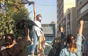 Women remove their headscarves during a protest in Iran. Ahead of the first anniversary of the death of 22-year-old Masha Amini in 'morality police' custody, the regime has enhanced its restrictive measures in anticipation of more protests. [Iran International]
