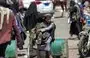 
یک دستفروش جوان در روز ۴ فروردین ۱۴۰۱ روی یک بلوک سیمانی نشسته است. او ژاکت‌هایی با طرح موسوم به چریکی در دست دارد و آنها را به عابران در خیابانی در صنعا، پایتخت یمن، می‌فروشد. [محمد حویس/ خبرگزاری فرانسه]        