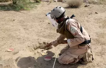 A member of Yemen's pro-government forces prepares a mine for remote detonation in the village of Hays in Yemen's western province of al-Hodeidah on August 11. [Khaled Ziad/AFP]