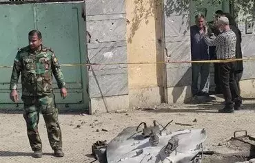 A member of the Iranian forces stands near debris from a projectile that fell on the city of Gorgan, the provincial capital of Golestan, during a failed military test. [IRNA]