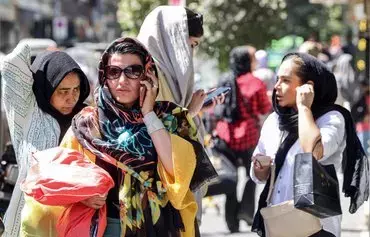 A woman speaks on a cell phone while walking along a street in Tehran on September 10. Iranian authorities have blocked popular social media networks, including Instagram and WhatsApp, since mass protests erupted in September 2022. [Atta Kenare/AFP]