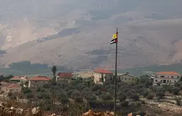 پرچم‌های فلسطینی و حزب‌الله در روز ۱۸ مهر در دشت خیام در جنوب لبنان برافراشته شده است. شهر متولا در شمال اسرائیل در زمینهٔ تصویر دیده می‌شود. [جوزف عید/ خبرگزاری فرانسه]