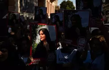 Protesters hold banners with the portrait of Iranian Mahsa Amini as they take part in a rally outside the Iranian consulate in Istanbul on September 29, 2022, following Amini's death 13 days earlier. On October 19, the European Parliament awarded the Sakharov Prize to Amini and to the movement her death triggered. [Yasin Akgul/AFP]