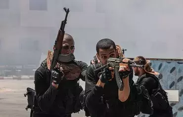 اعضای یک دانشکدهٔ پلیس که توسط جنبش فلسطینی حماس اداره می‌شود در ۱۱مرداد در یک جلسهٔ آموزشی در شهرک خان یونس، در جنوب نوار غزه، شرکت کرده‌اند. [سعید خطیب/ خبرگزاری فرانسه]