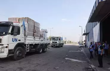 UN aid is loaded on trucks to be distributed to Palestinian families in the central Gaza city of Deir al-Balah on October 28, amid the ongoing battles between Israel and the Palestinian militant group Hamas. [Mohammed Abed/AFP]