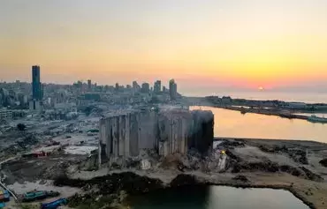 This aerial view shows the damaged grain silos at the port of the Lebanese capital Beirut, on August 3, 2022, following a partial collapse due to an ongoing fire. Two years prior, the port's massive explosion that many attributed to Hizbullah's negligence killed more than 200 people and devastated a huge section of the city. [AFP]