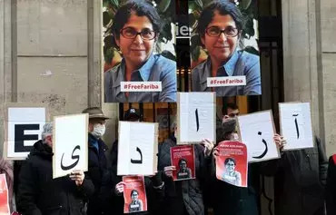 Colleagues of Iranian-French academic Fariba Adelkhah hold placards bearing her photo as they gather in Paris on January 13, 2022, to call for her freedom. [Thomas Coex/AFP]