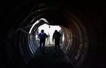 در این عکس که در جریان یک بازدید رسانه‌ای سازماندهی‌شده توسط ارتش اسرائیل در روز ۲۴ آذر گرفته شده، روزنامه‌نگاران در حال بازدید از تونلی هستند که بنا بر گزارش‌ها حماس از آن برای حمله به اسرائیل از طریق گذرگاه مرزی ایرز در روز ۱۵ مهر استفاده کرده است. ارتش اسرائیل روز ۲۶ آذر اعلام کرد که بزرگترین تونل حماس در نوار غزه تاکنون را که در فاصلهٔ چند صد متری با گذرگاه مرزی ایرز قرار دارد، کشف کرده است. [جک گُئز/ خبرگزاری فرانسه]
