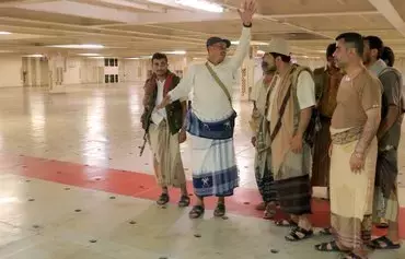 A picture taken during an organized tour by Yemen's Houthis on November 22, 2023, shows the group's minister of information, Dhaifallah al-Shami (2nd L), inspecting the Galaxy Leader Cargo ship, seized by Houthi militants two days earlier. The Houthis have turned the vessel into a domestic 'tourist attraction.' [AFP]