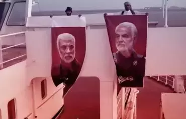 Screen grab of a video published by the Iran-backed Houthi group on January 20 shows two Houthi militants holding pictures of slain IRGC commander Qassem Soleimani (right) and Iraqi paramilitary commander Abu Mahdi al-Muhandis (left) on Galaxy Leader, the ship the Houthis seized in the Red Sea. [X]