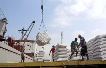 Workers unload wheat assistance provided by UNICEF from a cargo ship at the Red Sea port of al-Hodeidah in 2018. [Abdo Hyder/AFP]