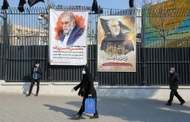 Posters of top nuclear scientist Mohsen Fakhrizadeh, killed in Tehran in November 2020, and slain IRGC Quds Force commander Qassem Soleimani, are seen in Tehran on December 30, 2020. [Atta Kenare/AFP]