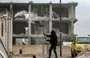 
A man chops firewood near a building damaged in the earthquake of February 2023 in the Aleppo town of Jindayris on February 5, 2024. Newly sanctioned IRGC-QF Unit 700 is accused of smuggling weapons into Syria under the pretext of providing earthquake aid. [Bakr Alkasem/AFP]        