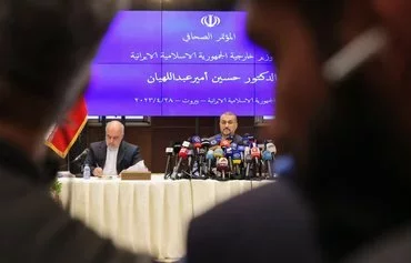 Iranian ambassador to Lebanon Mojtaba Amani (left) is seen alongside former Iranian Foreign Minister Hossein Amir-Abdollahian (right) at a press conference in Beirut on April 28, 2023. [Joseph Eid/AFP]