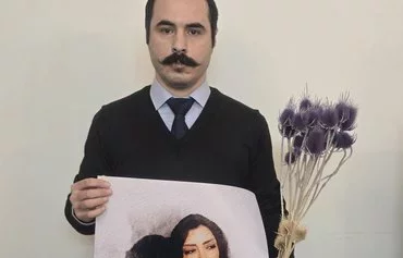 Civil rights activist Hossein Ronaghi, protesting with his lips sewn shut, holds a poster of Nasreen Shakarami and her teenage daughter Nika, who was killed by Iranian security forces in September 2022. [Hossein Ronaghi X account, November 24]