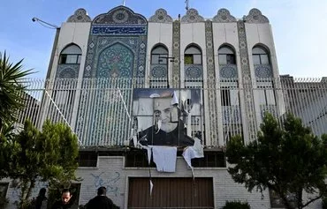 A portrait of slain IRGC Quds Force commander Qasem Soleimani hangs on the fence of the Iranian embassy in Damascus on December 9. [Louai Beshara/AFP]