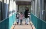 
A woman and her children cross a pedestrian bridge in Tehran on December 4. [Atta Kenare/AFP]        