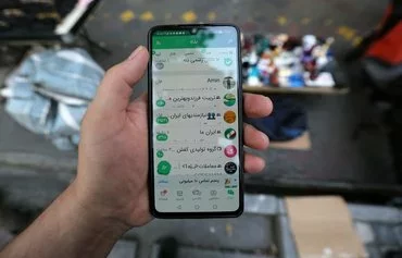 A man displays the domestic messaging app 'Bale' in Tehran on April 19, 2023. While local apps have gained popularity amid government restrictions, many users continue accessing blocked foreign platforms. [Atta Kenare/AFP]