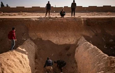 People search for remains in a suspected mass grave near Damascus, December 16, 2024. [Aris Messinis/AFP]