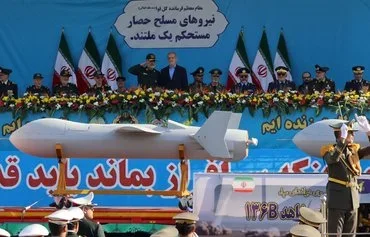 Iranian President Masoud Pezeshkian and Islamic Revolutionary Guard Corps Aerospace Force commander Amir Ali Hajizadeh look on as Iran's new Shahed 136-B drone is displayed during a military parade in Tehran on September 21, 2024. [Atta Kenare/AFP]