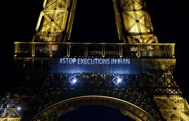 The words "Stop executions in Iran" are displayed on the Eiffel Tower in Paris on January 16, 2023. [Ludovic Marin/AFP]